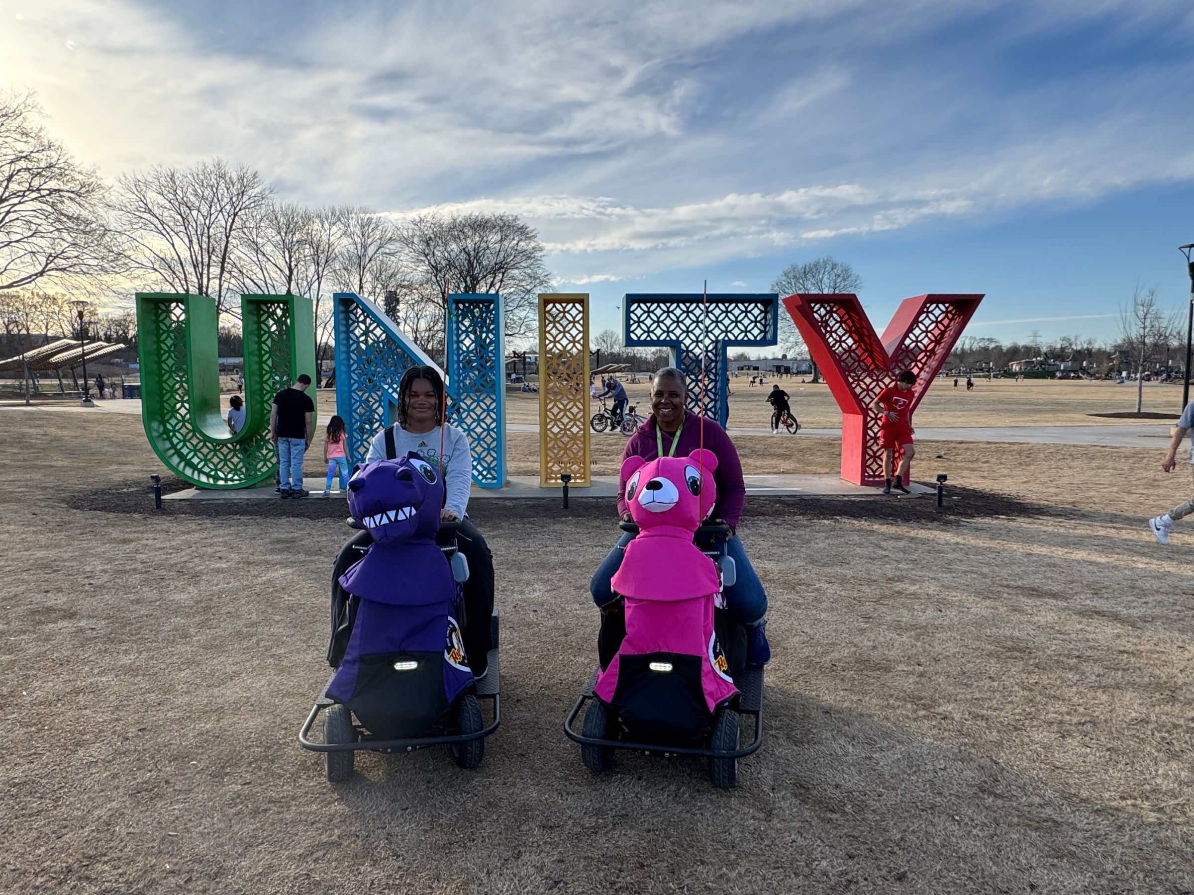 a group of people standing on top of a field with Cadillac Ranch in the background
