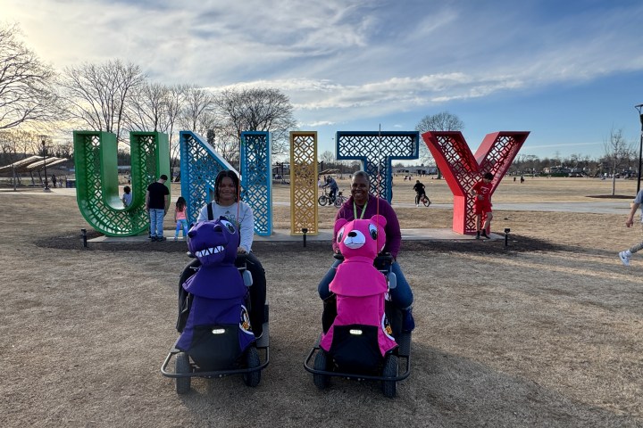 a group of people standing on top of a field with Cadillac Ranch in the background