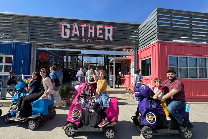 a group of people sitting on a motorcycle in front of a building