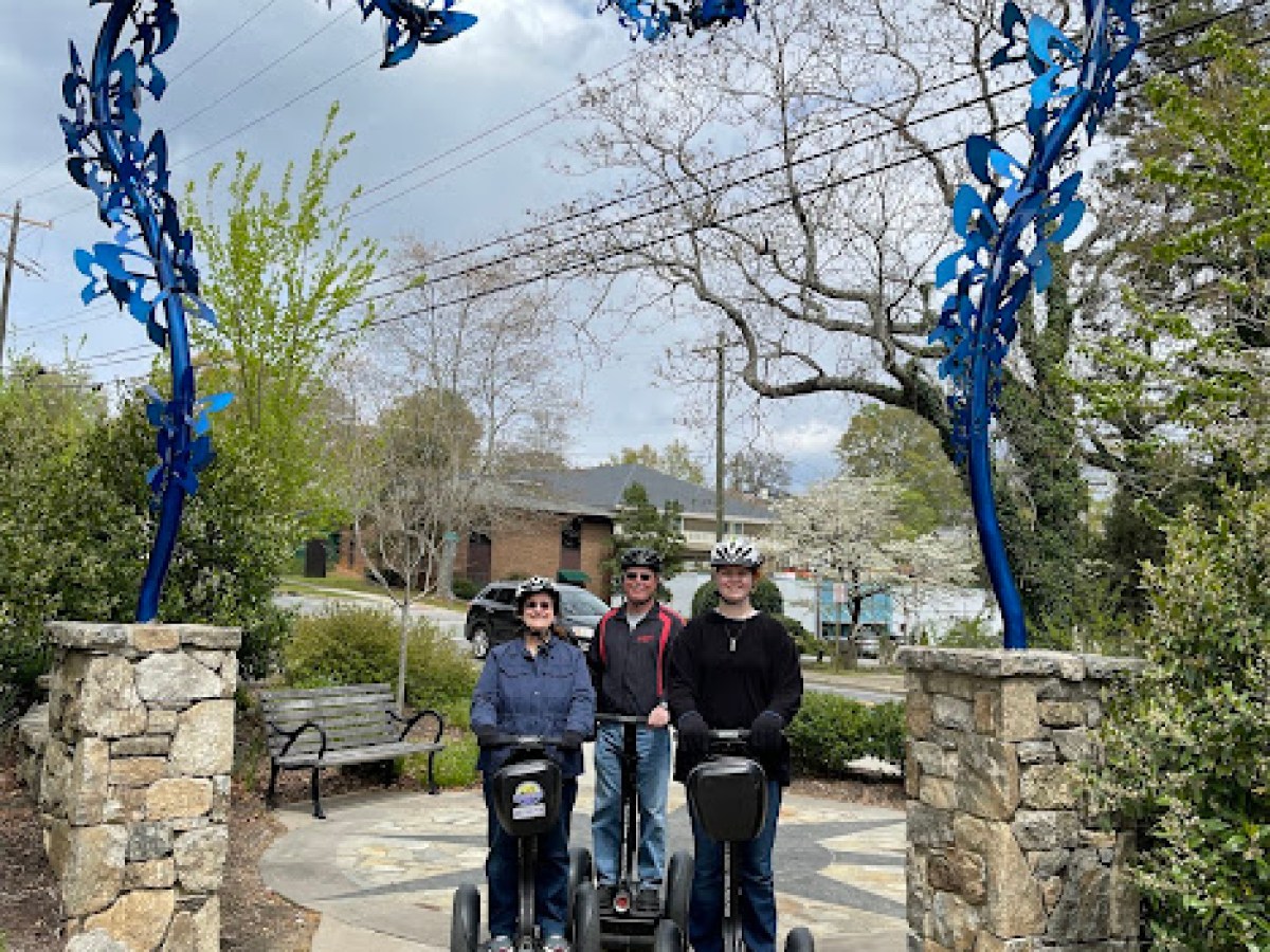 a group of people on a sidewalk next to a tree